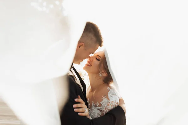 Retrato Casamento Noivo Terno Preto Noiva Loira Estão Abraçando Envoltos — Fotografia de Stock