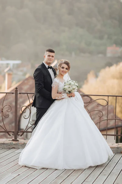 Γαμήλιο Πορτρέτο Γαμπρός Μαύρο Κοστούμι Και Ξανθιά Νύφη Στέκονται Αγκαλιασμένοι — Φωτογραφία Αρχείου