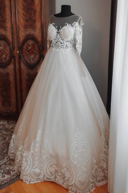 Gelinin odasında siyah bir mankenin üzerinde dantel kollu nefis bir gelinlik. Yüksek kalite fotoğraf. Düğün detayları. Nakışlı, bembeyaz bir elbise.