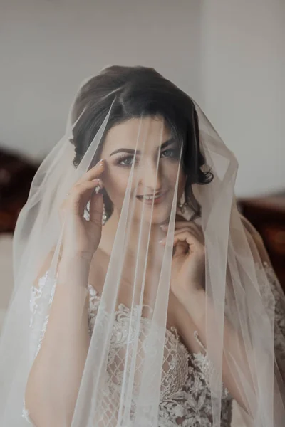 Retrato Uma Noiva Morena Vestido Branco Envolta Véu Olha Para — Fotografia de Stock