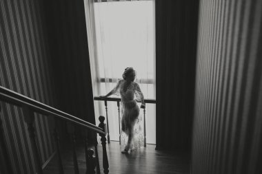 Moda fotoğrafı, şeffaf cüppeli güzel bir kız. Moda, cazibe konsepti. Gelinin sabahı, bornozlu gelin, ön taraftan fotoğraf. Siyah beyaz fotoğraf