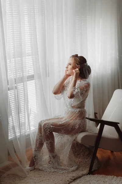 Невеста Прозрачном Халате Сидит Краю Мягкого Розового Кресла Светлой Комнате — стоковое фото