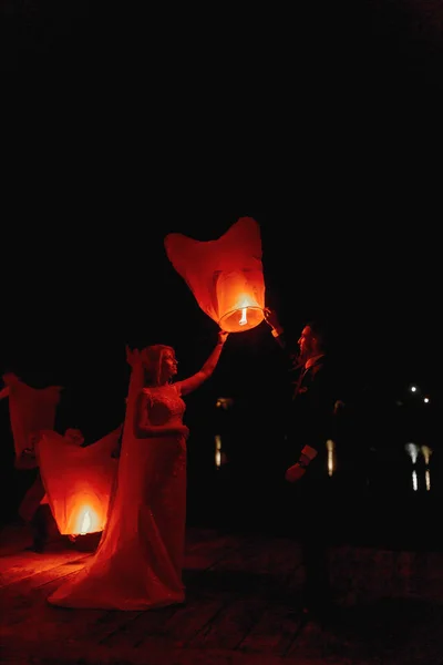Casal Recém Casado Abraçando Uns Aos Outros Com Lanternas Vermelhas — Fotografia de Stock