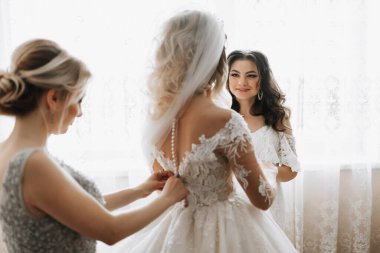 Sabah gelin. Nedime elbisesinin kadar bağlama gelin yardım. Kız elbise tutturmak için gelin yardım