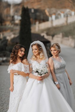 Şık nedimeler gelinle doğada eğlenir, poz verir ve geline bakarlar.