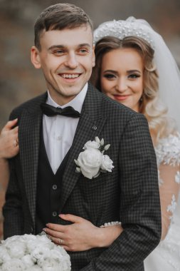 Düğün günlerinde gelin ve damadın genç bir çift portresi. Gelin damada arkadan sarılıyor. şık bir portre. Yakın plan.