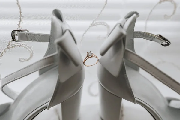 Βέρα Της Νύφης Στέκεται Ανάμεσα Κομψά Λευκά Παπούτσια Ελαφρύ Φόντο — Φωτογραφία Αρχείου