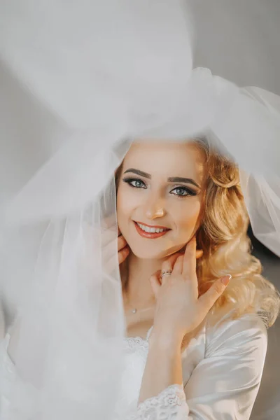 Ξανθιά Νύφη Είναι Ντυμένη Σατέν Ρόμπα Και Ξαπλώνει Καναπέ Ποζάροντας — Φωτογραφία Αρχείου