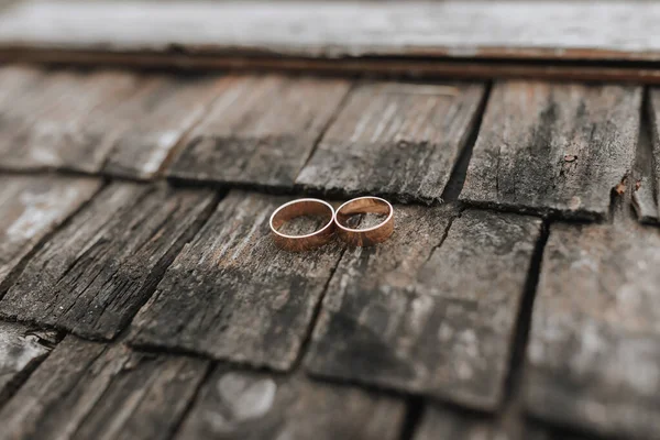 배경에 금고리가 쌍달려 거침없는 결혼반지에 단풍나무 표면이 애호가들을 — 스톡 사진