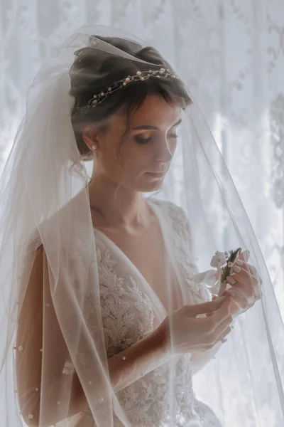 一个穿着白衣的黑发新娘摆出一副婚纱的样子 法国修指甲 张开肩膀漂亮的手长长的面纱新娘的早晨 — 图库照片