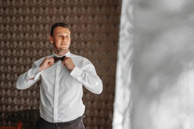 adam kelebek kıyafetler, papyon üzerinde koyarak işadamı. Takım elbise, eller, bakım, kravat düzeltmek için ayarlamak, moda, yay için.