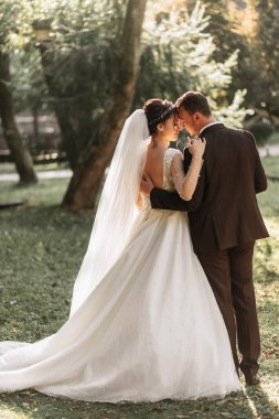 Gelin ve damat el ele ormandan geçiyorlar. Arka plan