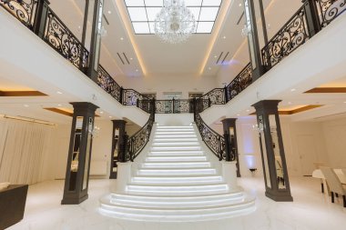 Güzel bir merdiveni ve avizesi olan lüks bir kraliyet iç mimarisi. Geniş pencereli parlak büyük salon