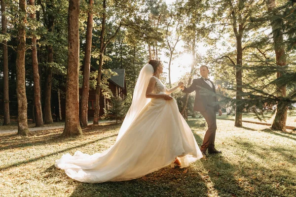 年轻新娘和新郎日落时在高尔夫球场绿草上散步的全身像 后视镜 新婚夫妇快乐 复制空间 — 图库照片