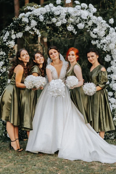 新婦付添人は花嫁と一緒に笑っています 花嫁と彼女の楽しい友人は 一致したドレスで儀式の後の結婚式を祝います 自然界の花嫁と友人 — ストック写真