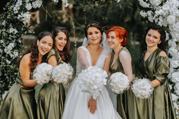 新婦付添人は花嫁と一緒に笑っています 花嫁と彼女の楽しい友人は 一致したドレスで儀式の後の結婚式を祝います 自然界の花嫁と友人 — ストック写真
