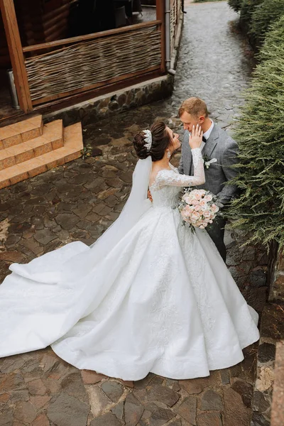 Svatební Fotka Nevěsta Objemných Bílých Šatech Dlouhém Závoji Stojí Ženichem — Stock fotografie