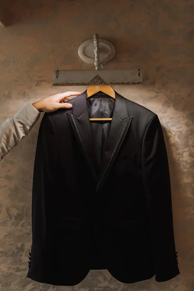 Чорна Куртка Висить Приміщенні Рука Бізнесмена Тримає Чорну Куртку — стокове фото