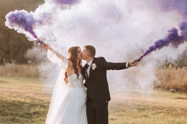 新娘们用紫色的手拿着彩烟玩耍 婚礼上的烟雾弹 — 图库照片