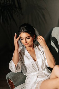 Odasında stüdyo ışığı olan gelinin portresi. Harika saç ve makyaj. Gelinin sabahı. Düğün hazırlıkları.