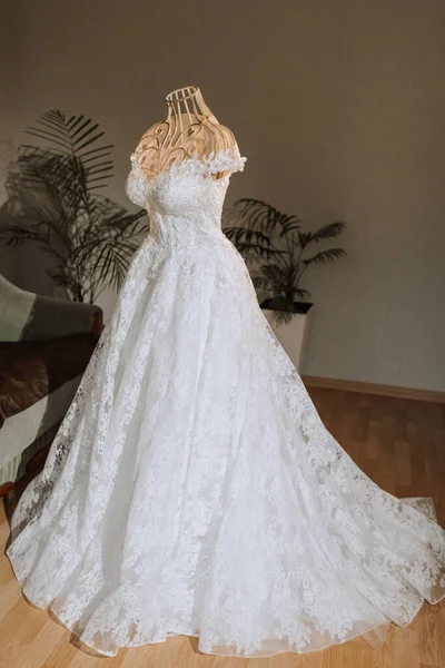Women's wedding dress in home room on mannequin, preparation for wedding ceremony, bride's morning at home