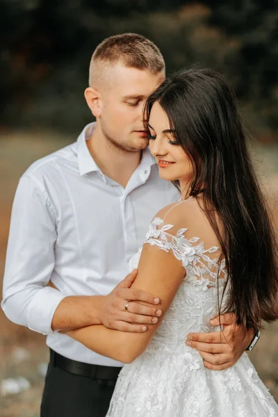 Noivo Abraça Noiva Pelos Ombros Beija Seu Templo Close Mãos — Fotografia de Stock