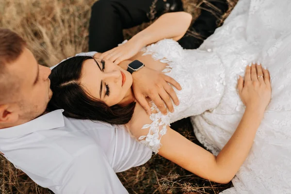 Bruden Och Brudgummen Ligger Det Torra Gräset Och Kramas Kvinna — Stockfoto