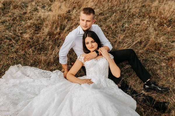 Braut Und Bräutigam Liegen Auf Dem Trockenen Gras Und Umarmen — Stockfoto