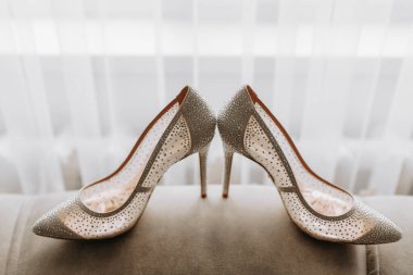 Modaya uygun, düğün, beyaz arka planda bej renkli yüksek topuklu kadın ayakkabıları.