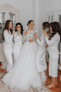 Beyaz ipek elbiseli genç nedimeler gelinin odasında şampanya içerler. Bekarlığa veda partisini kutlayan güzel kadınlar odada şampanyayla bekliyor..