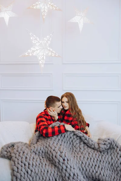 Junge Schöne Eheleute Passenden Roten Pyjamas Sitzen Auf Einem Grauen — Stockfoto