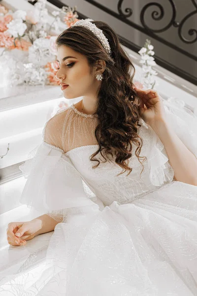 一个年轻姑娘的画像 她的头发和妆容都很漂亮 穿着华丽的婚纱 躺在楼梯上 玫瑰花盛开 一个宽阔的计划的照片 自由空间 — 图库照片