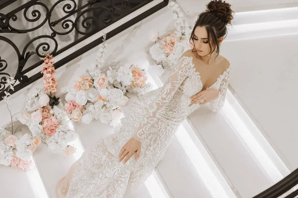 花で飾られた階段の豪華なウェディングドレスの女の子 — ストック写真