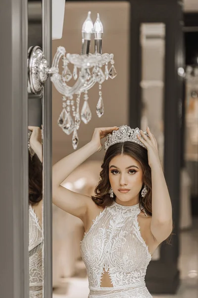 一个穿着婚纱 头戴皇冠的女孩在镜子旁边的画像 皇家宴会的概念 垂直照片 — 图库照片