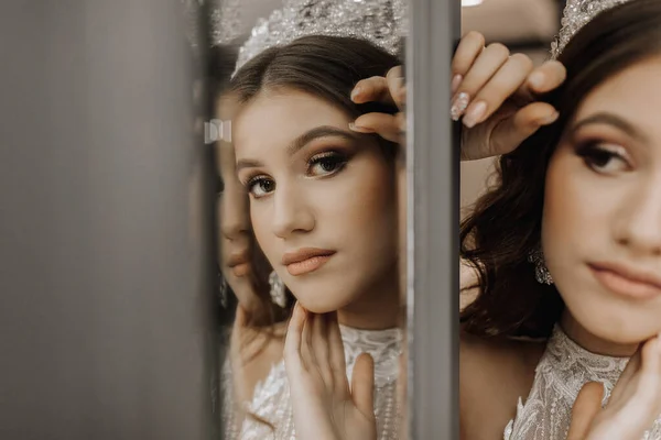 一个穿着婚纱 头戴皇冠的女孩在镜子旁边的画像 皇家宴会的概念 横向照片 — 图库照片