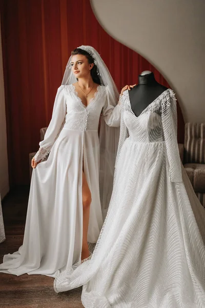 Брюнетка Невеста Одета Длинный Атласный Халат Стоящий Рядом Манекеном Платьем — стоковое фото