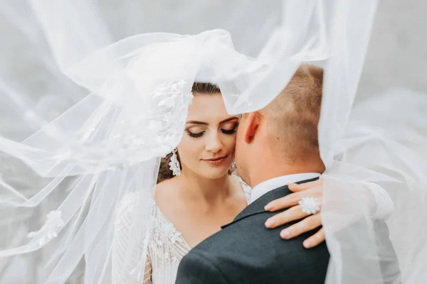 結婚式の肖像画 長いドレスと古典的なスーツのグロムのブルネットの花嫁は 湖の背景に恋して立っています — ストック写真