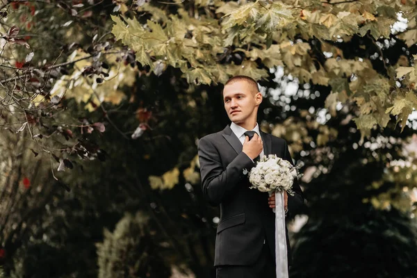 Foto Brudgummen Klassisk Svart Kostym Med Bukett Blommor Händerna — Stockfoto