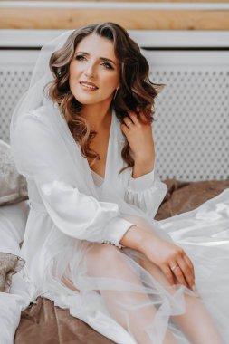 Gelin düğün için hazırlanıyor. Uzun siyah saçlı, bornozlu bir kız.