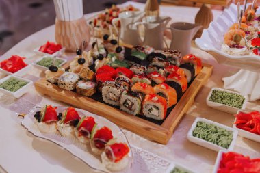 Düğün kutlamalarında farklı lezzetli yemeklerden oluşan büyük bir açık büfe. Misafirler için atıştırmalıklar. Düğün partisi. Kanepeler, suşi, meyve, et, içecek, şarap, meyve suyu.