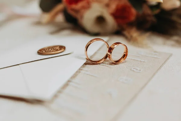 gold wedding rings near the envelope with wedding vows. Selective focus
