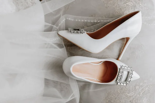 斯沃罗夫斯基石制的白色女鞋 混乱地站在新娘的面纱旁边 特写照片 — 图库照片