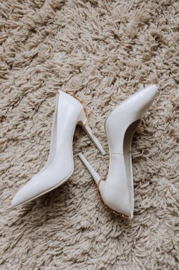 Kadın yüksek topuklu ayakkabıları bir battaniyenin üzerinde yatıyor. Gelinin detayları.