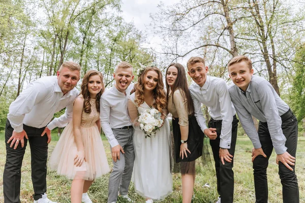 숲에서 신부와 그들의 친구들은 배경에 그룹의 사람들이 그들의 친구의 결혼식에서 — 스톡 사진