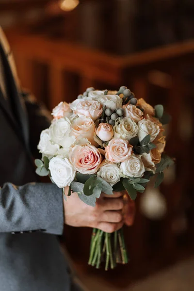 一个男人拿着一束婚礼用的白玫瑰和粉红玫瑰 — 图库照片
