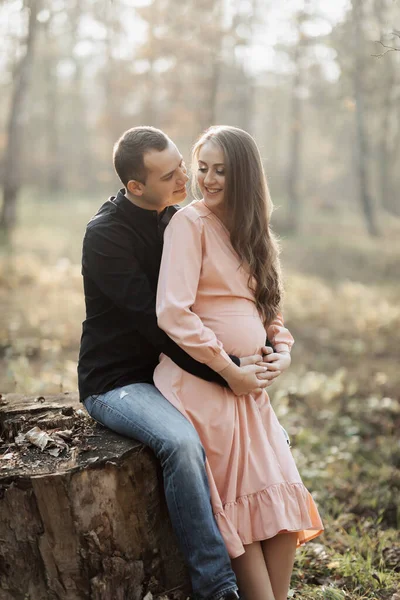 남성과 임신한 아내는 일몰에 숲에서 포옹하고 키스합니다 행복한 — 스톡 사진