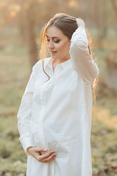 Uma Mulher Grávida Vestido Branco Fundo Escuro Posa Parque Gravidez — Fotografia de Stock