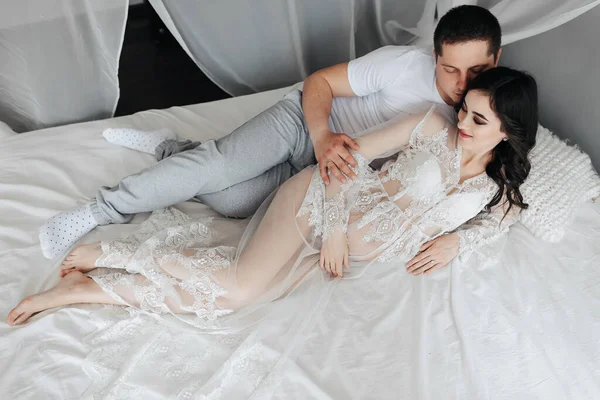 Joven Morena Embarazada Habitación Vestido Encaje Blanco Cama Con Marido —  Fotos de Stock