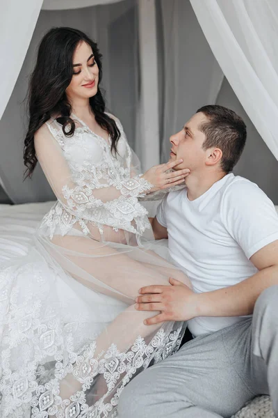 Una Joven Embarazada Cama Con Vestido Encaje Blanco Marido Mira —  Fotos de Stock