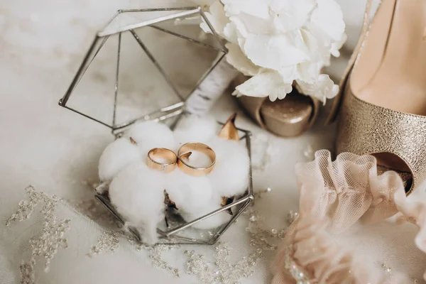 新娘衣服的细节 金婚戒指装在一个玻璃装饰盒中 站在棉花花上 新郎的婚礼花 金黄色的女式高跟鞋 — 图库照片